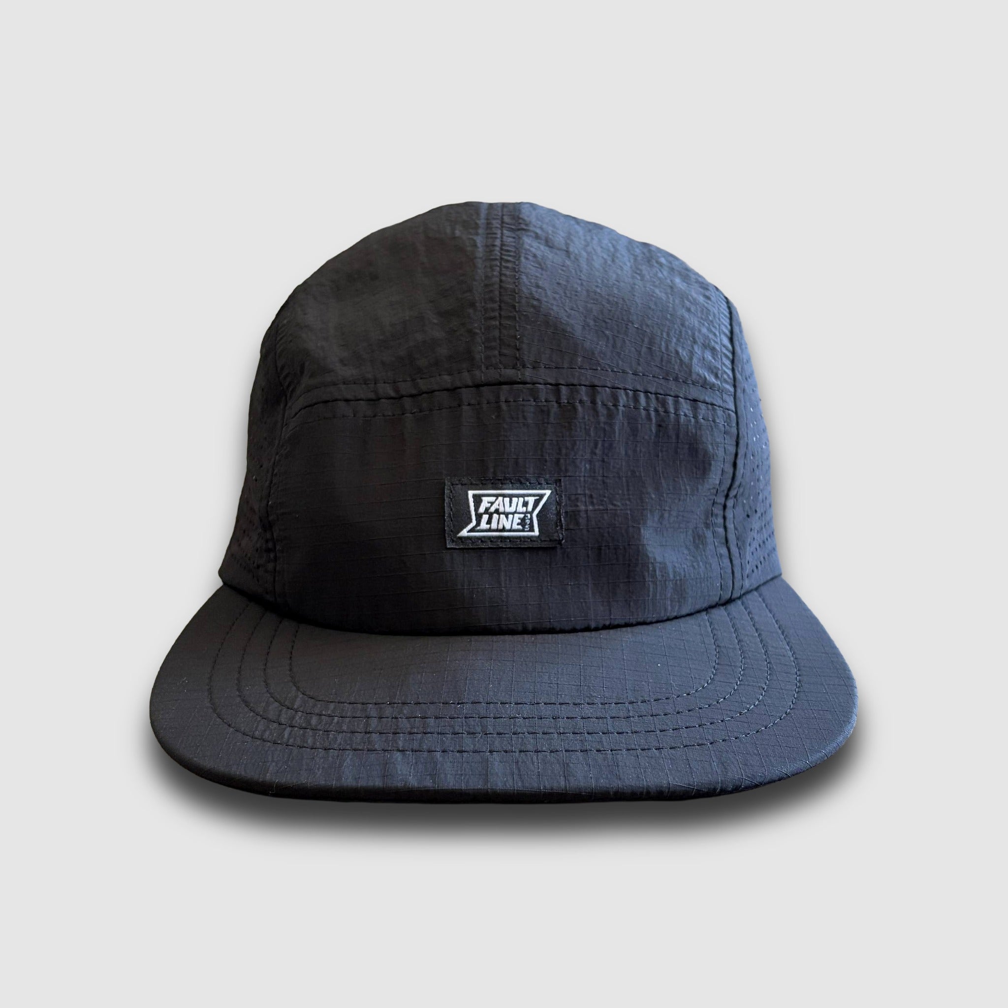 Black camper hat with a logo on a light gray background
