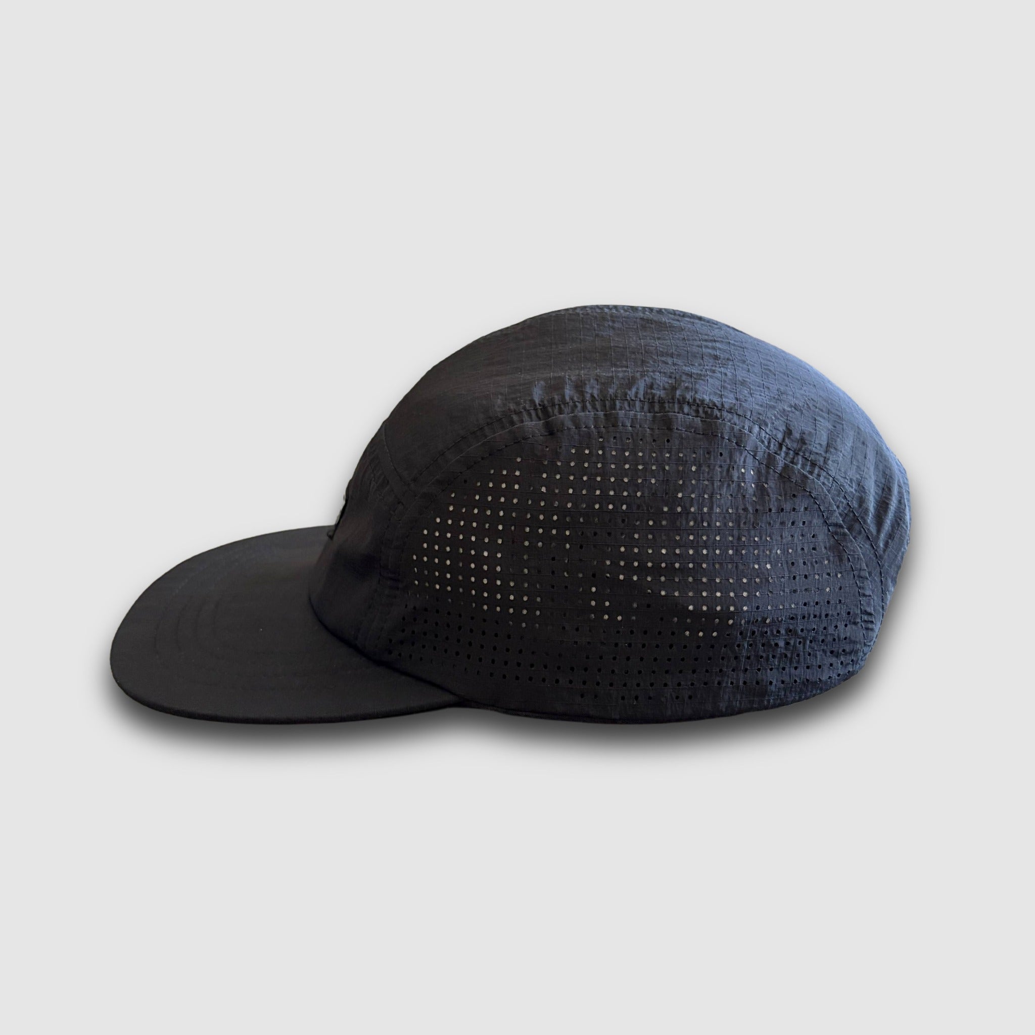Black runner cap with ventilation holes on the side panels