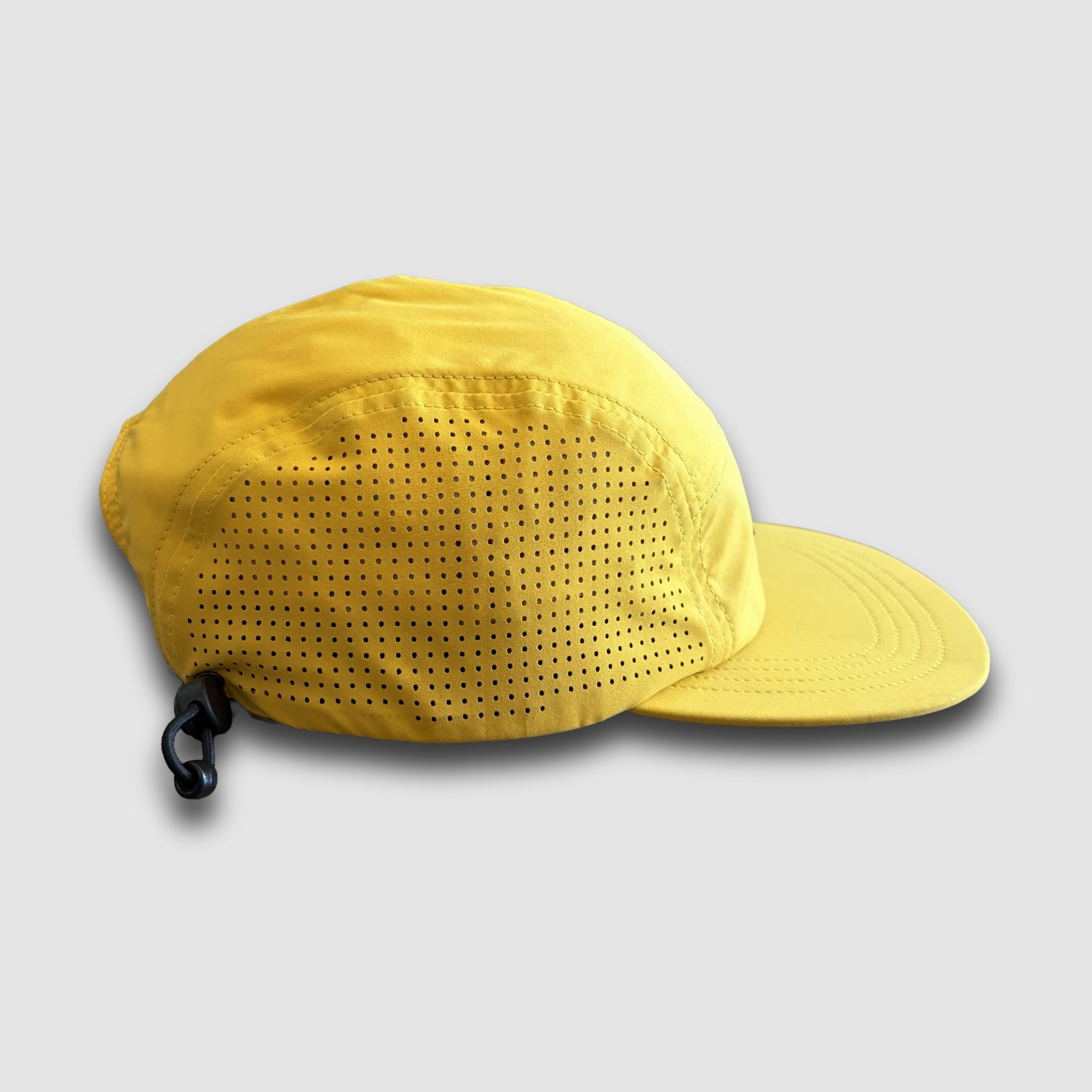 Yellow cap with ventilation holes on a light gray background