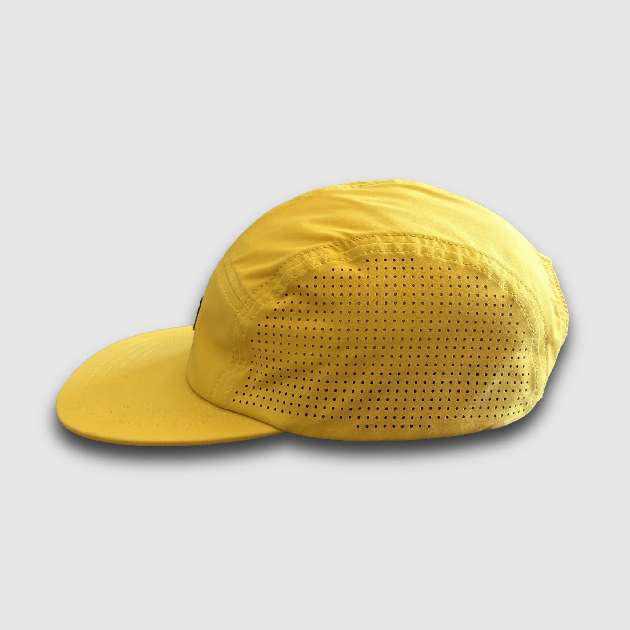 Yellow 5-Panel cap with perforated design on a light gray background