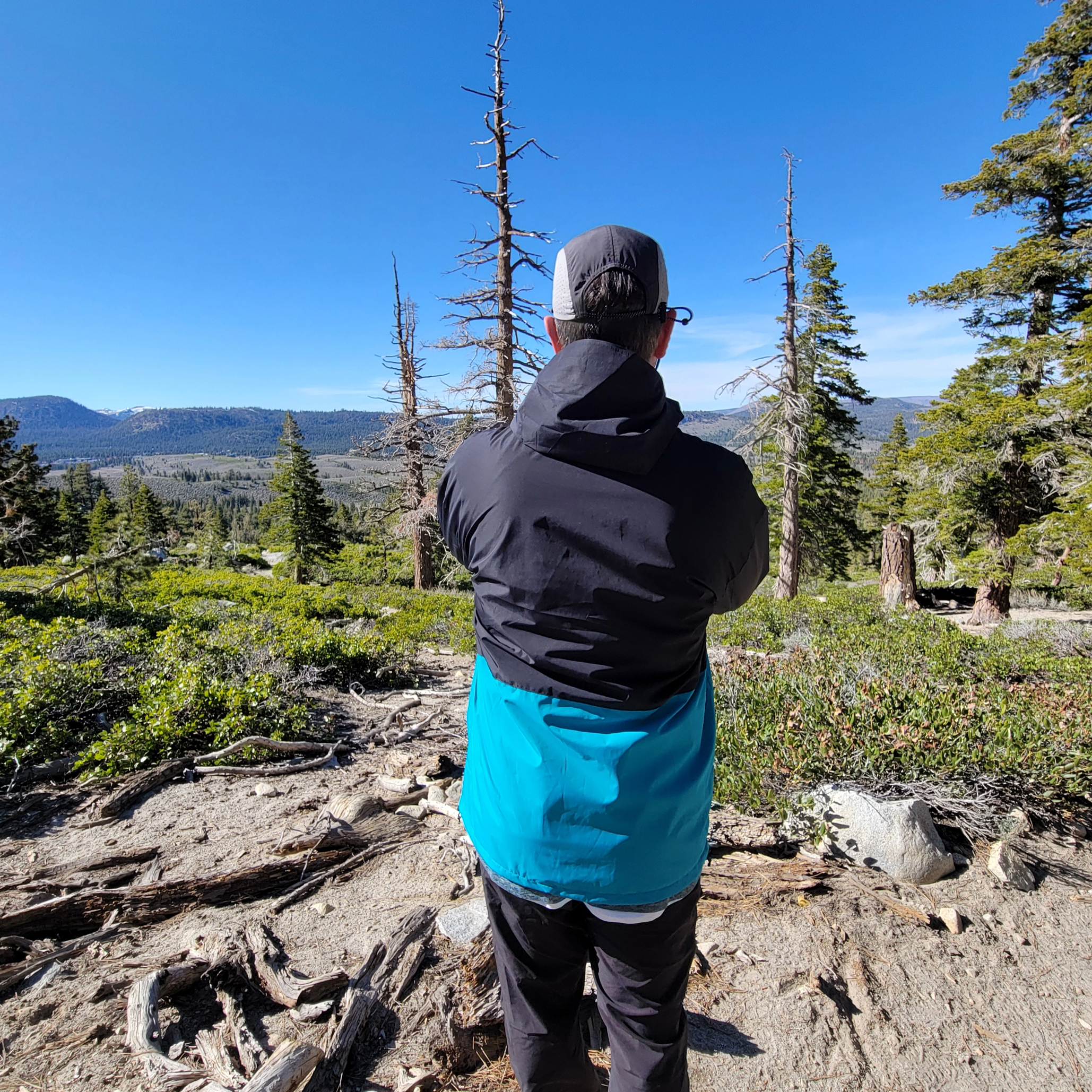 Back view of a hiker wearing Faultline395's Forest Trail Jacket, highlighting its lightweight and waterproof fabric.