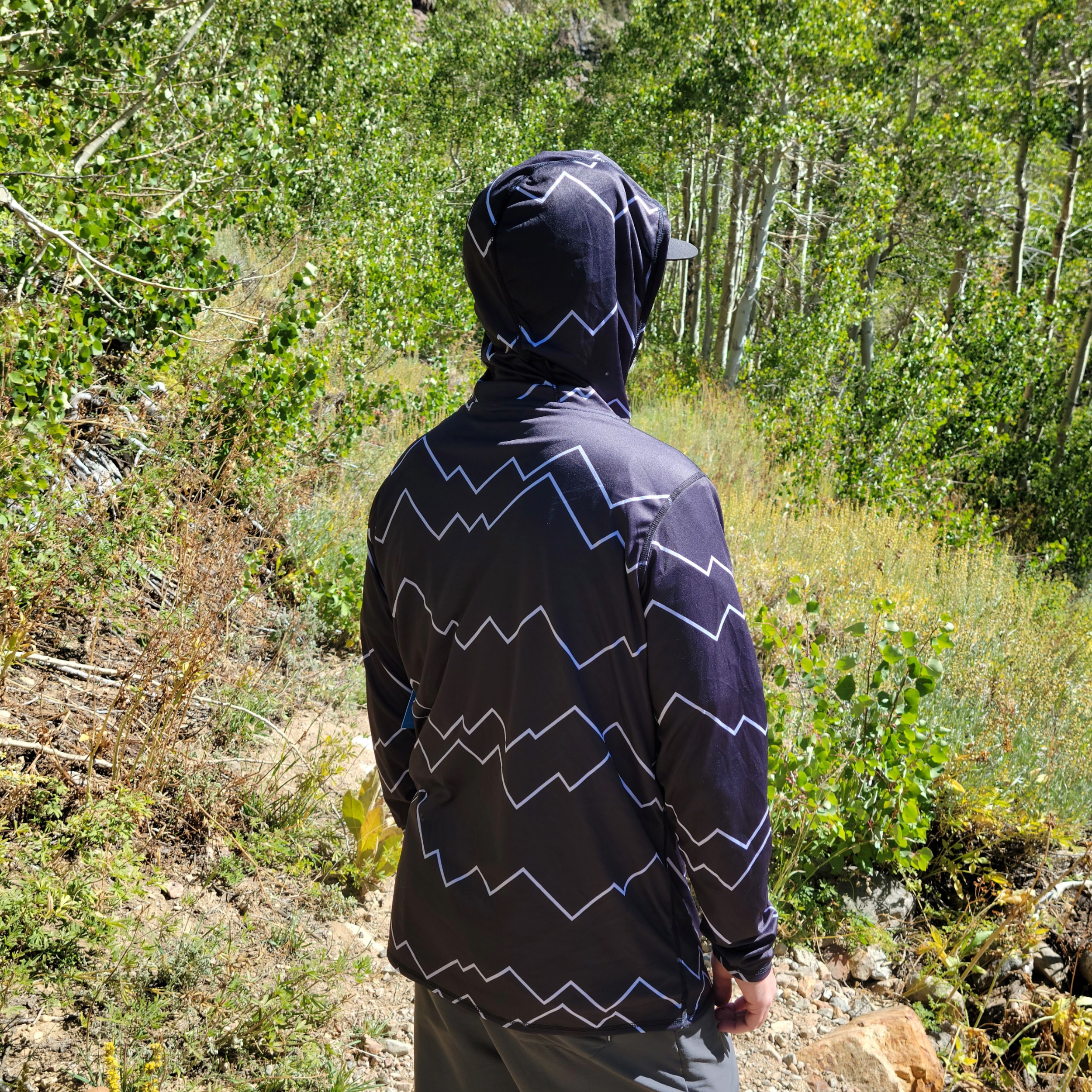 Person wearing the Carson Sun Hoodie from Fualtline395 while enjoying a mountain view