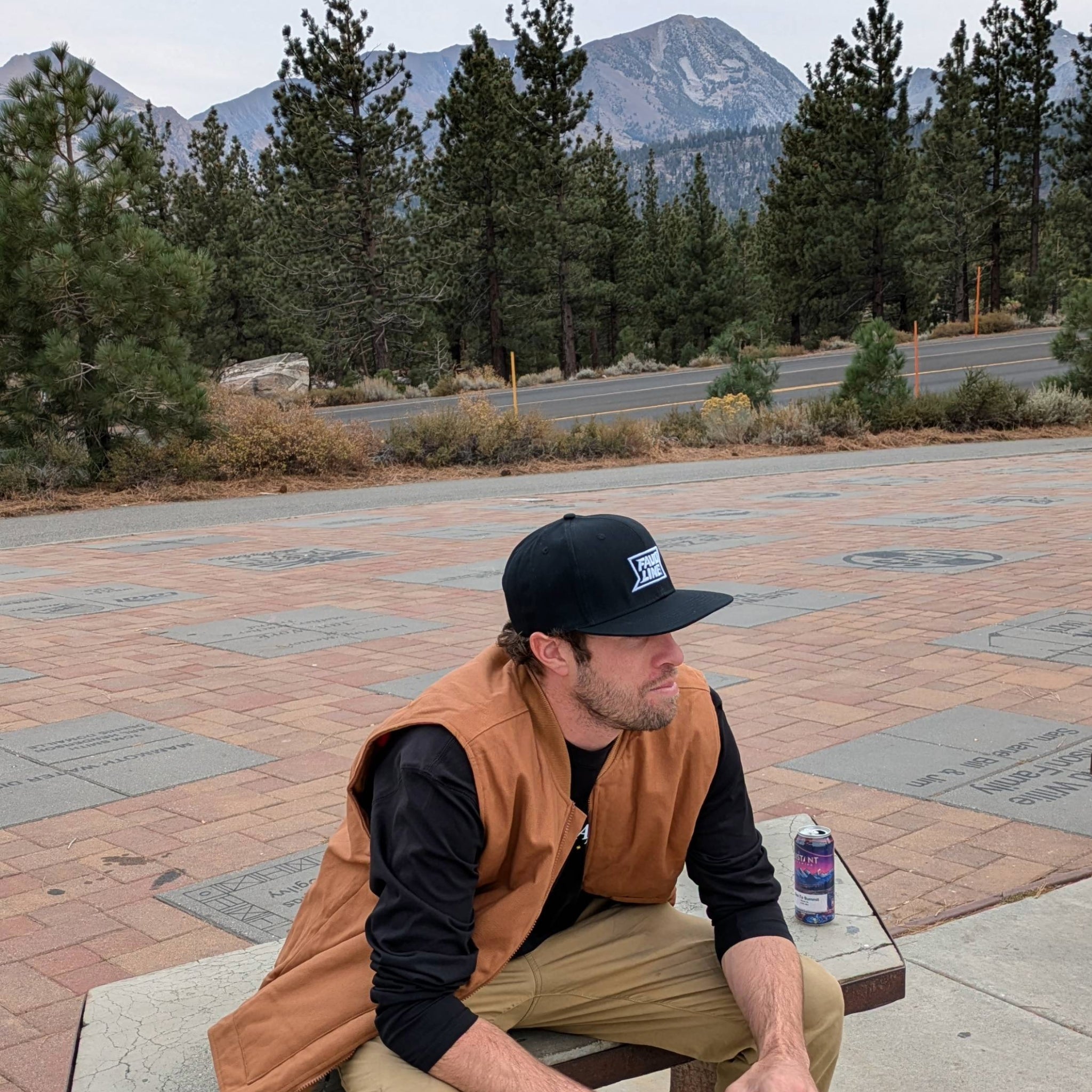 Model wearing the Buffalo Check Snapback hat outdoors, combining urban style with rugged mountain aesthetics
