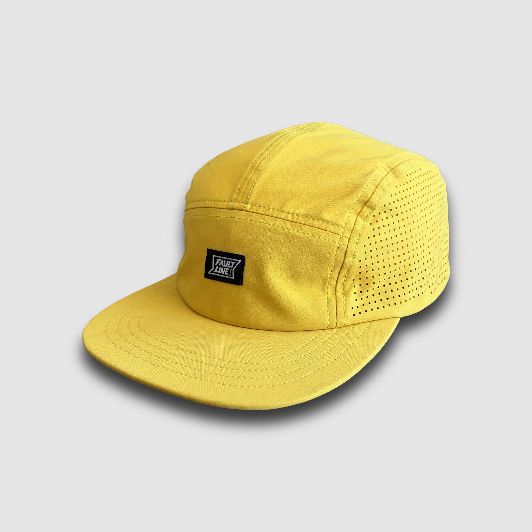 Yellow Camper Hat with a Faultline395 brand logo on a light gray background
