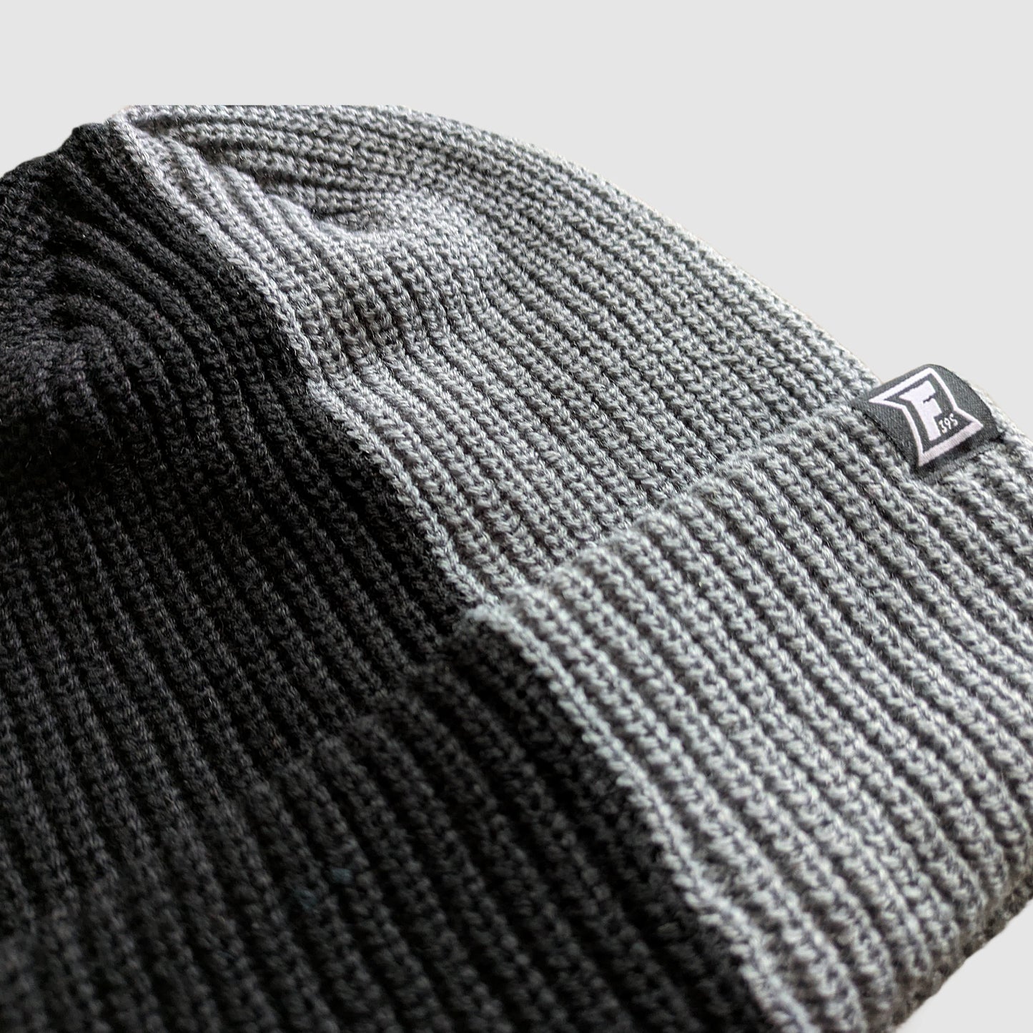 Close up shot of a split color beanie in black and gray