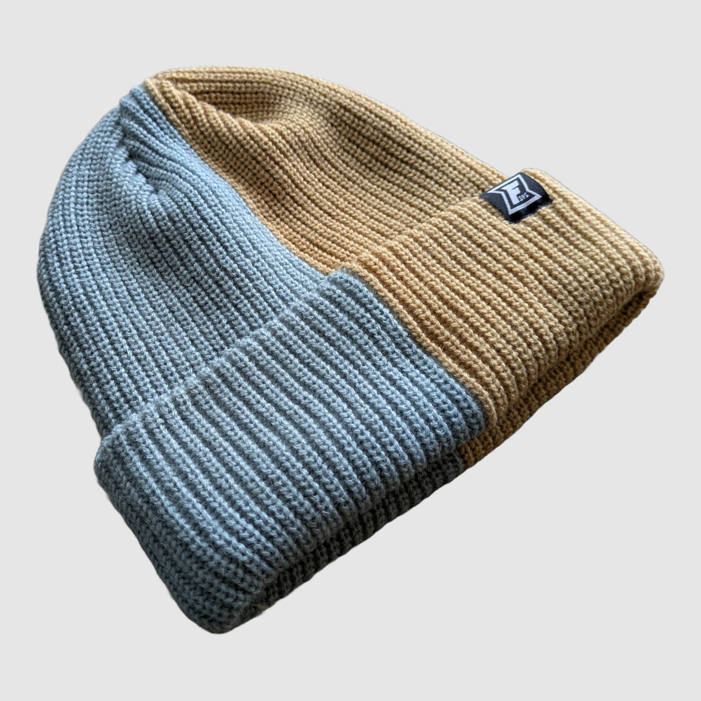 Detailed view of the tan and blue split color beanie.