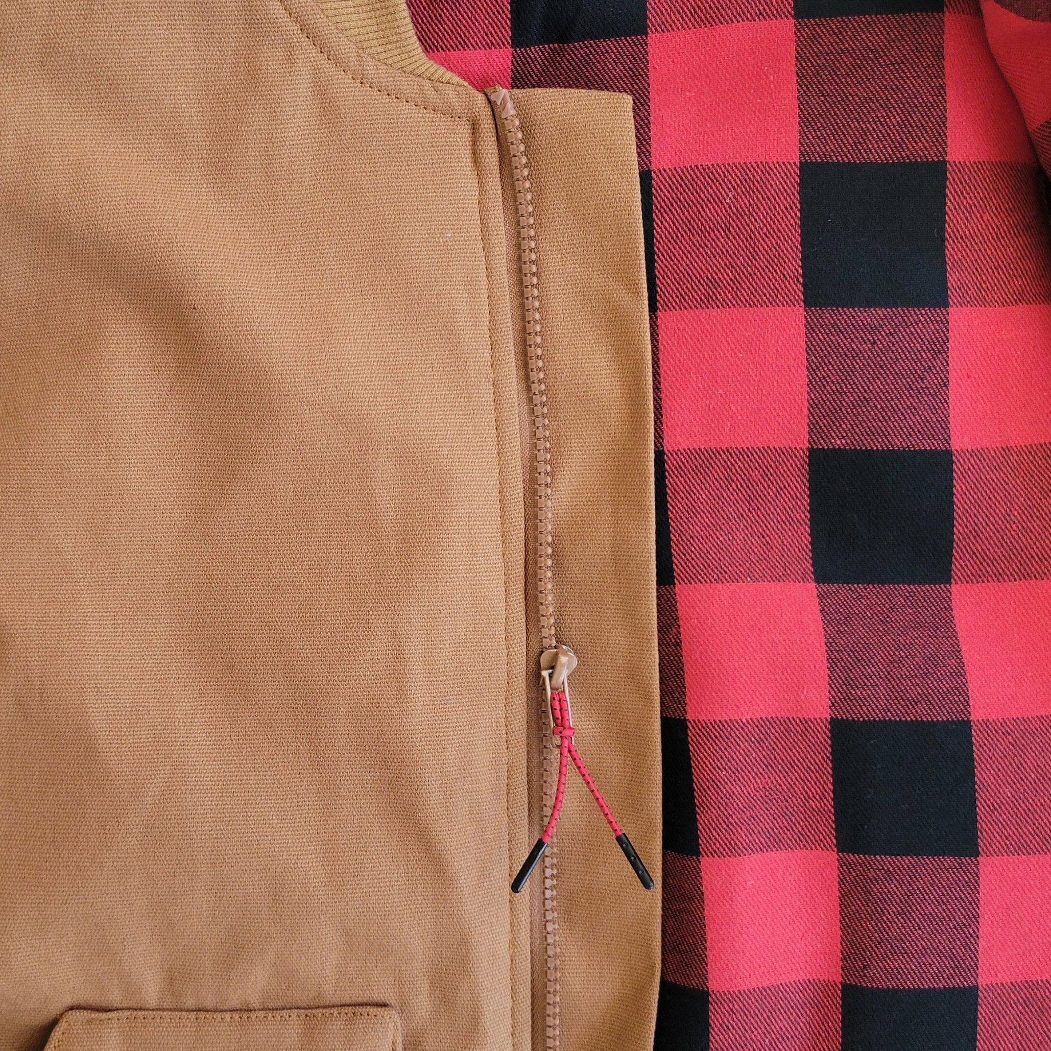 Closeup of the red and black buffalo check liner on our insulated work vest.