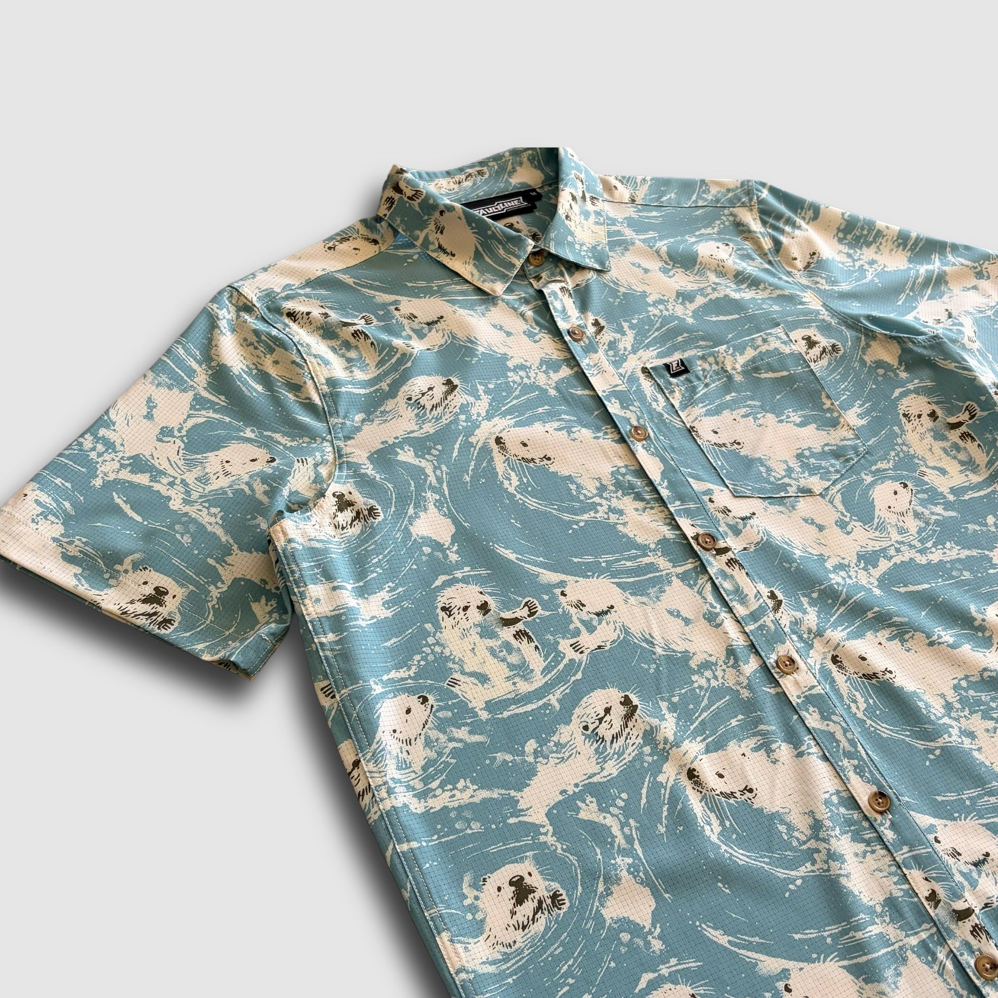 Performance button up shirt in light blue with a sea otter design