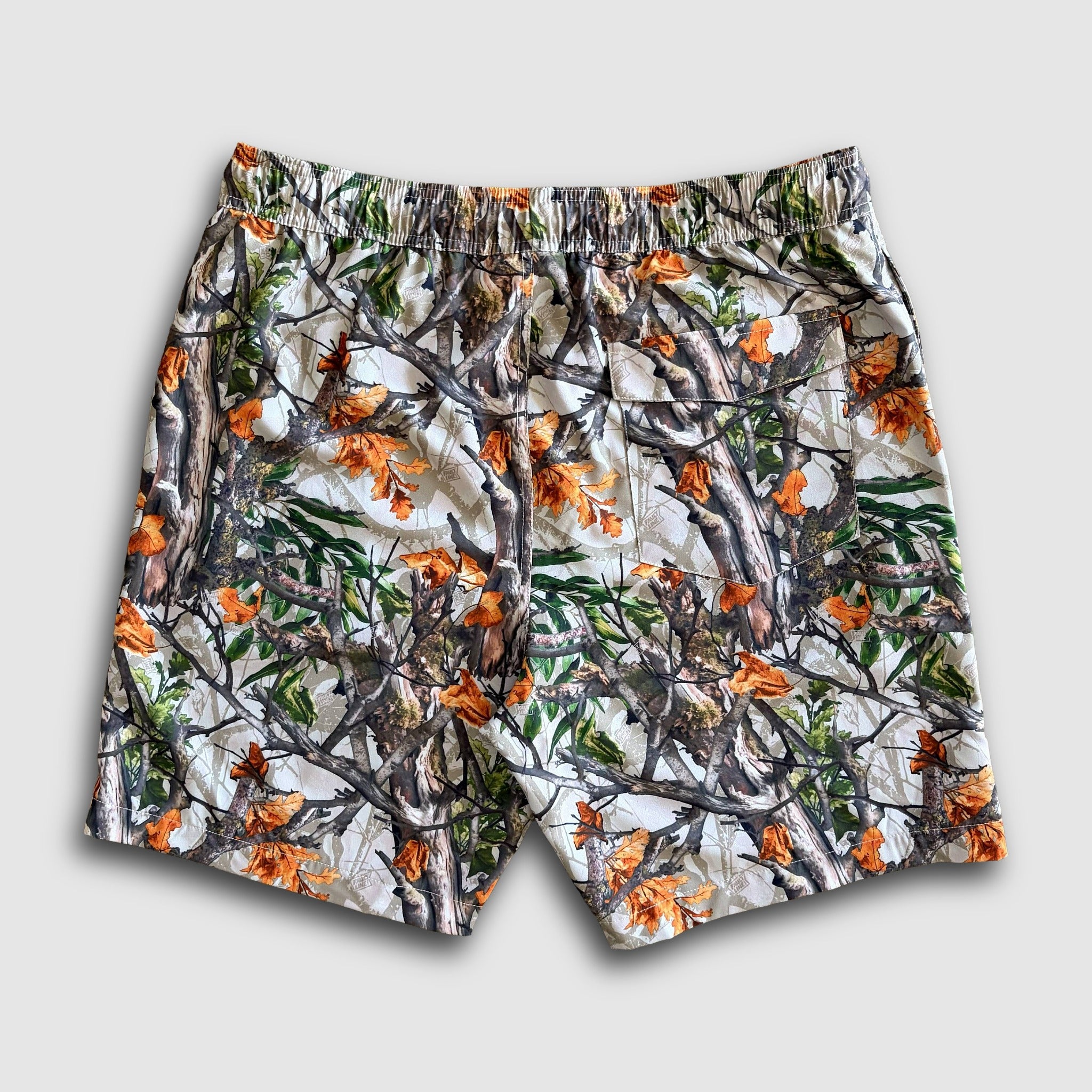 Camouflage-patterned shorts with orange accents on a light gray background