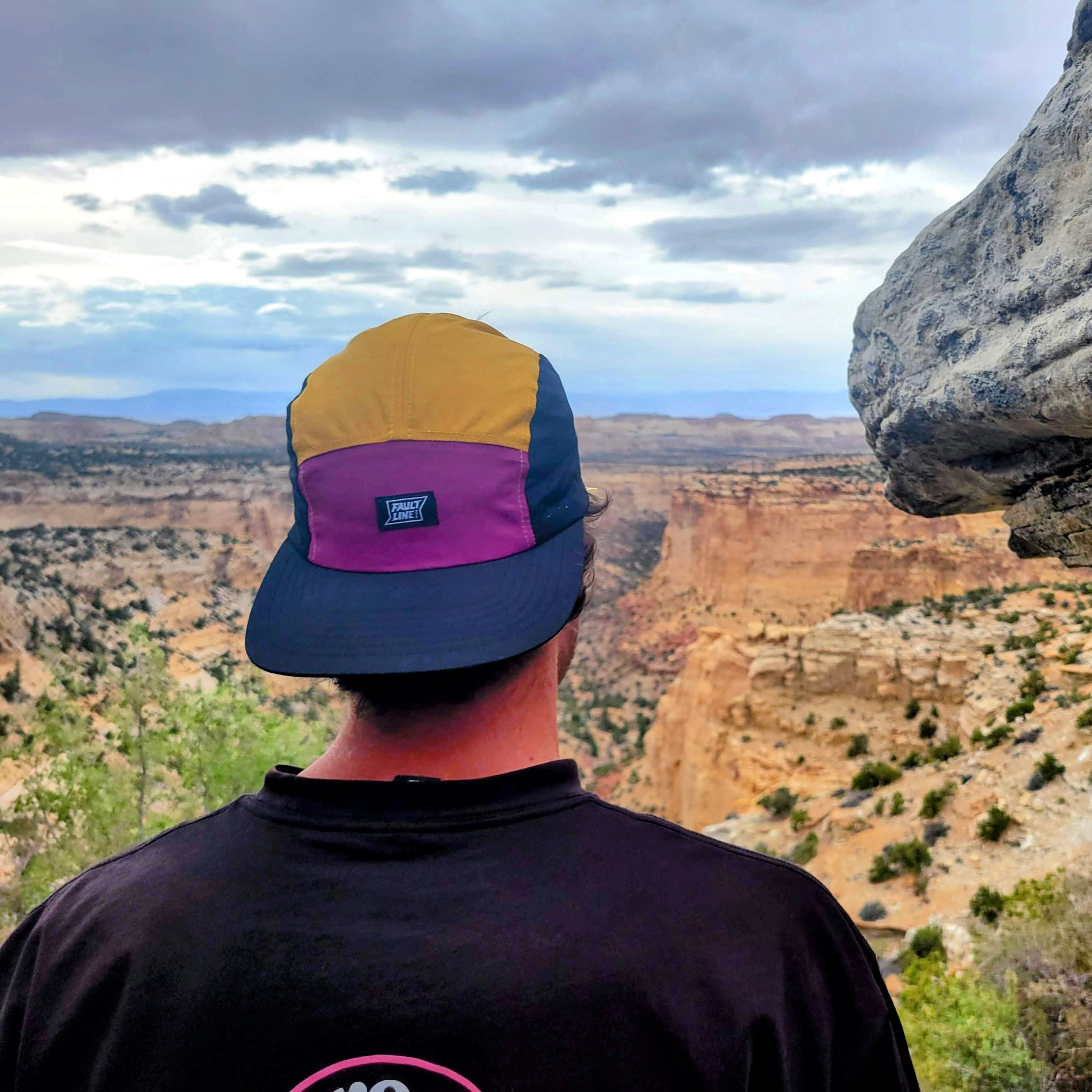 Model wearing the Ultralight Camper hat backwards while looking at the view of a canyon
