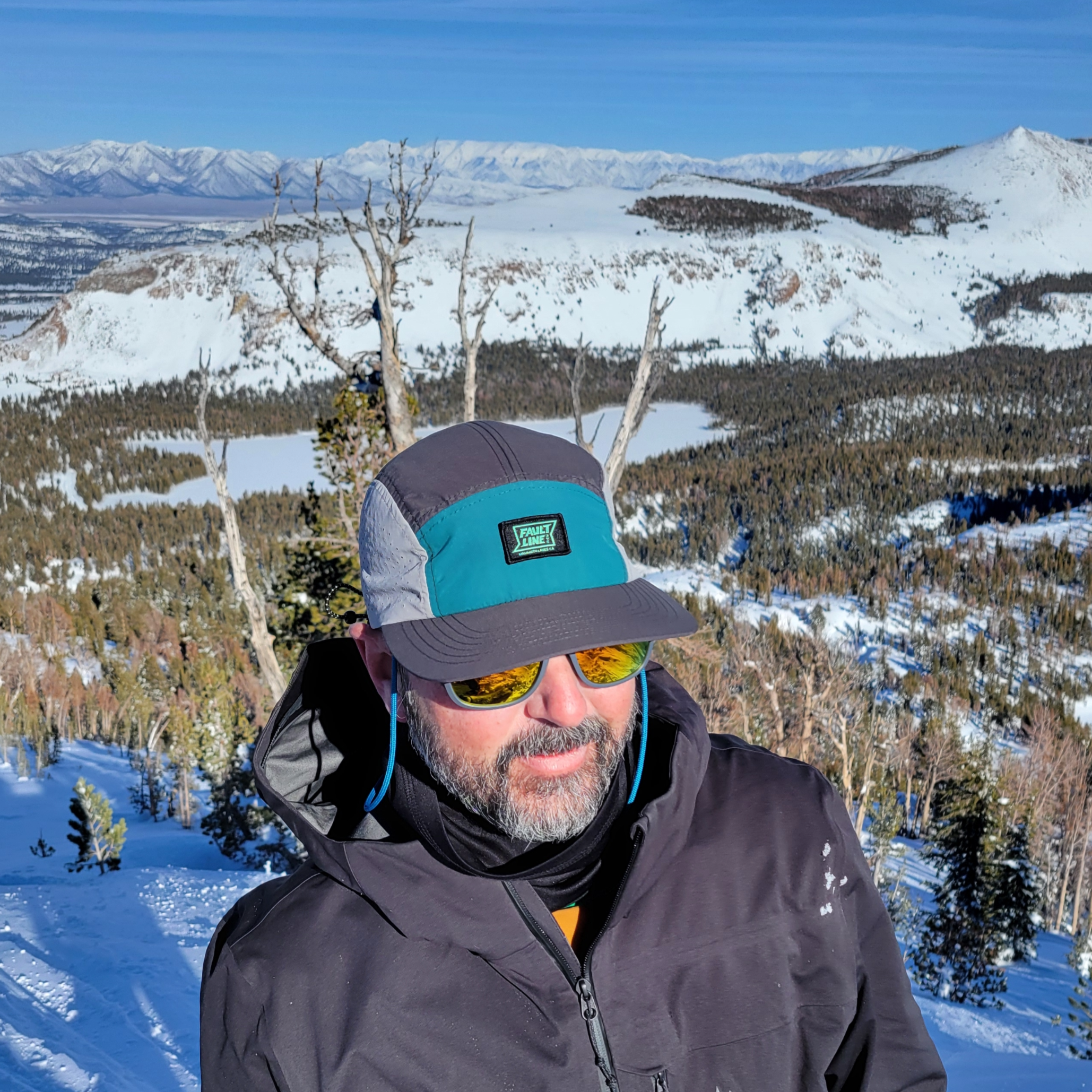 Model wearing the Faultline395 5-Panel hat in the backcountry demonstrating it's performance features