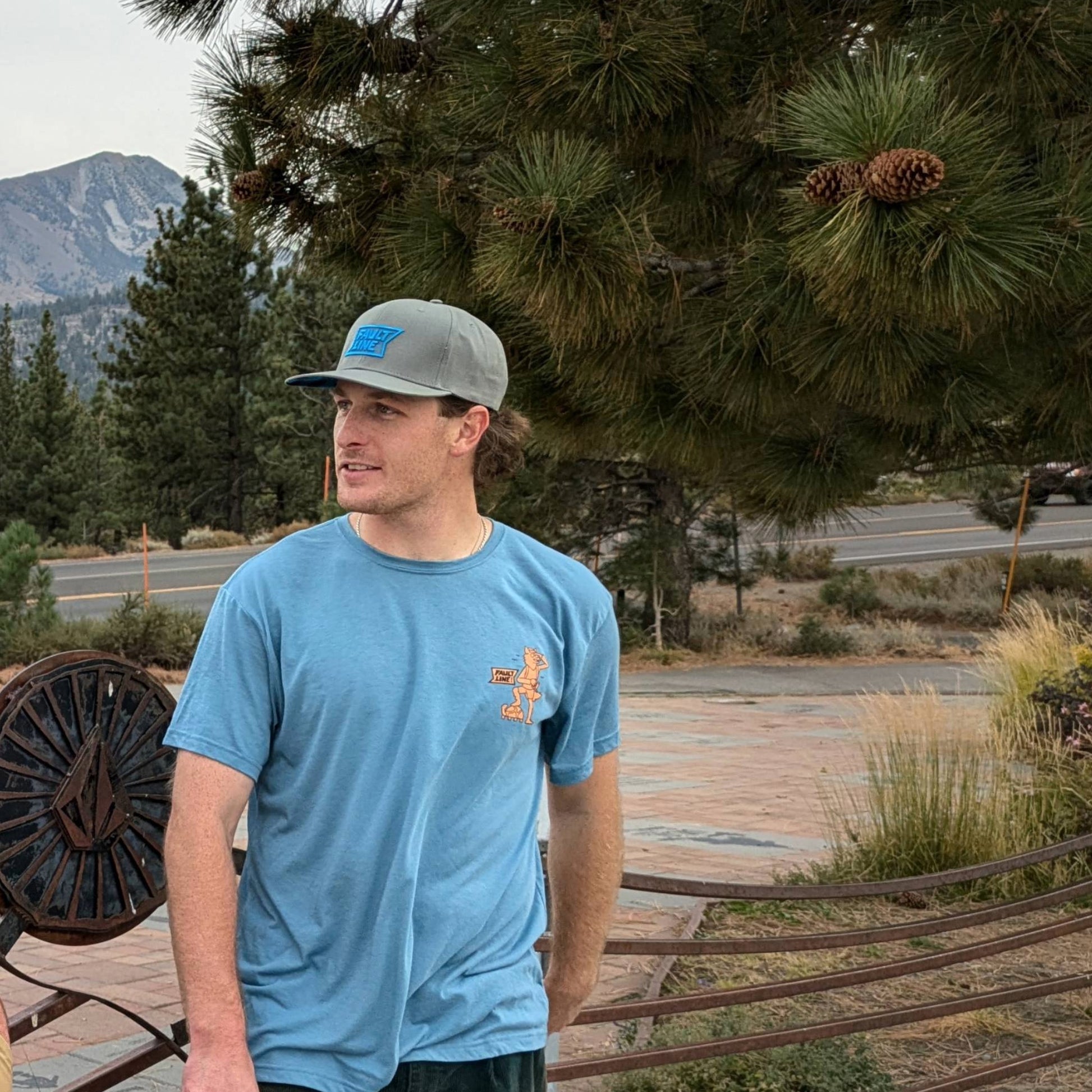 Model wearing the Buffalo Check Snapback in the mountains, combining urban style with rugged outdoor aesthetics