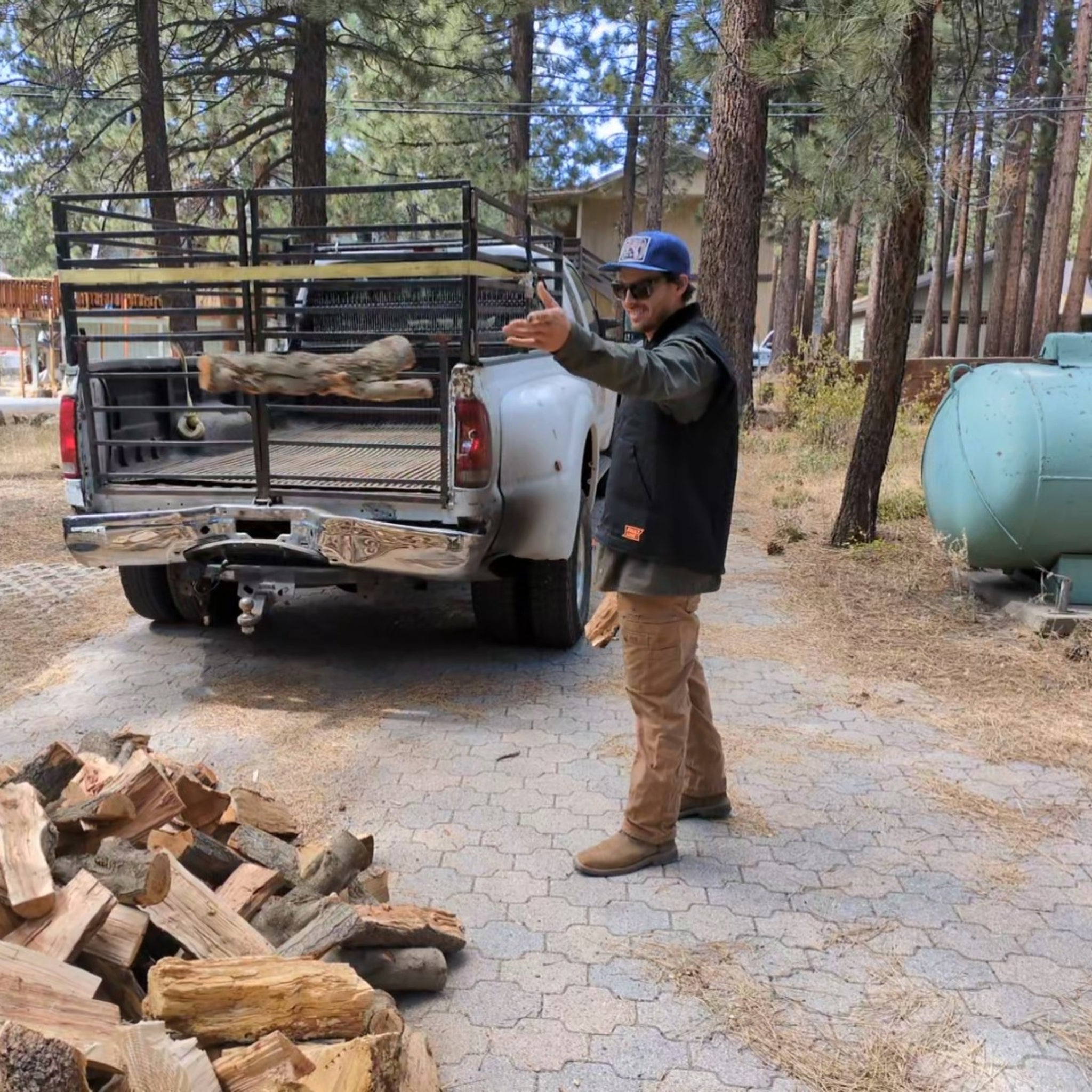 Person demonstrating the durability of the Faultline395 Work Vest by stacking firewood